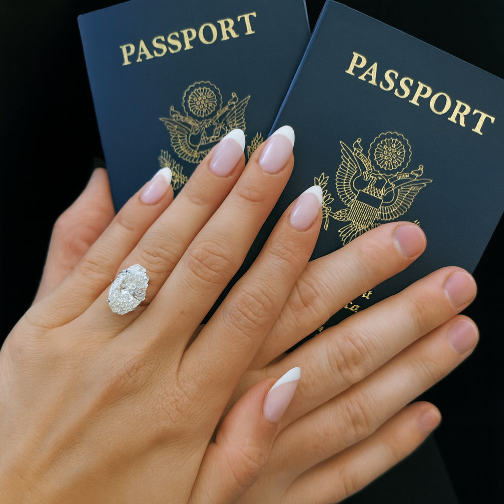 Oval diamond engagement ring on hand holding two passports