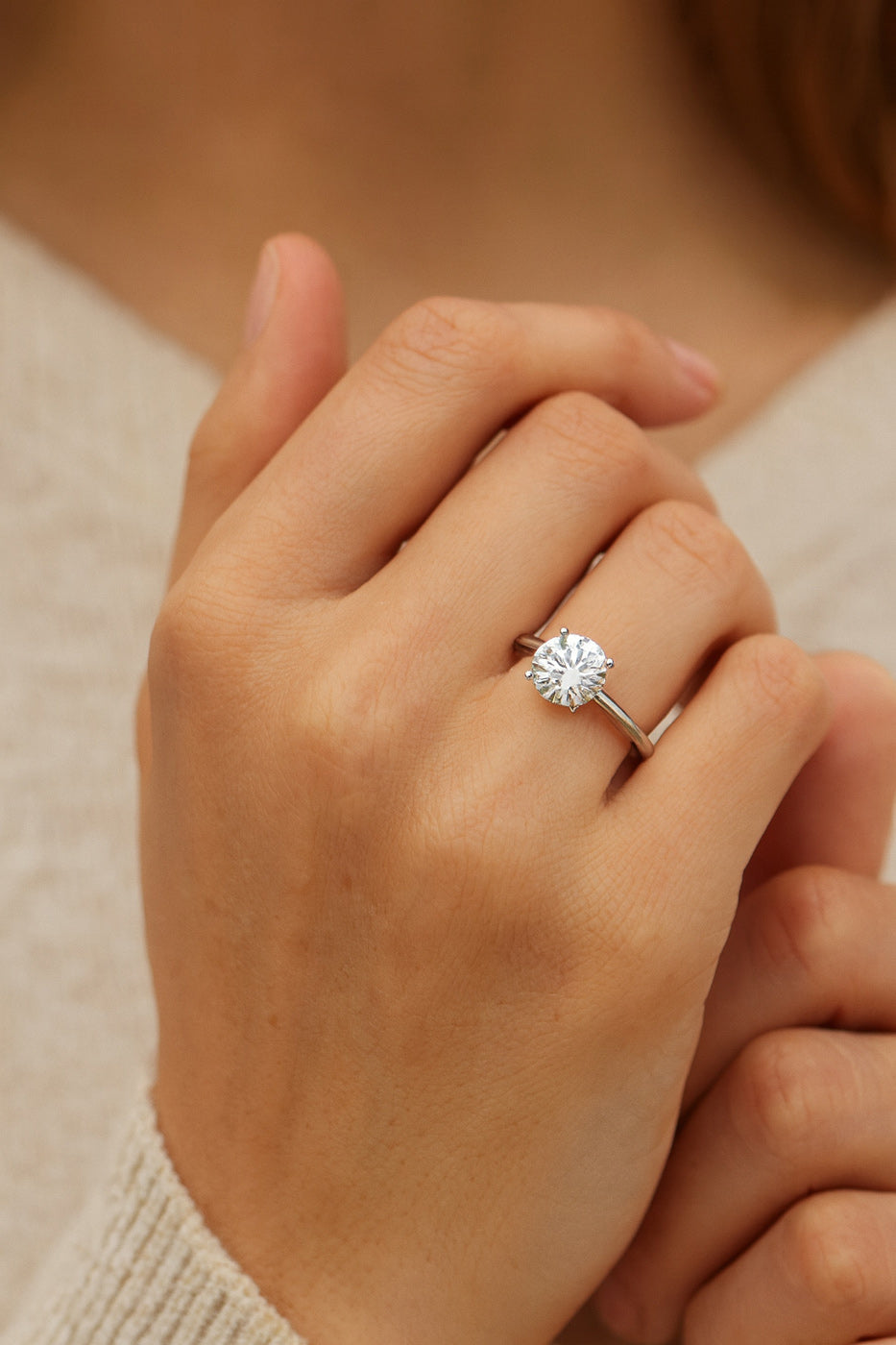 Platinum round diamond solitaire engagement ring on hand