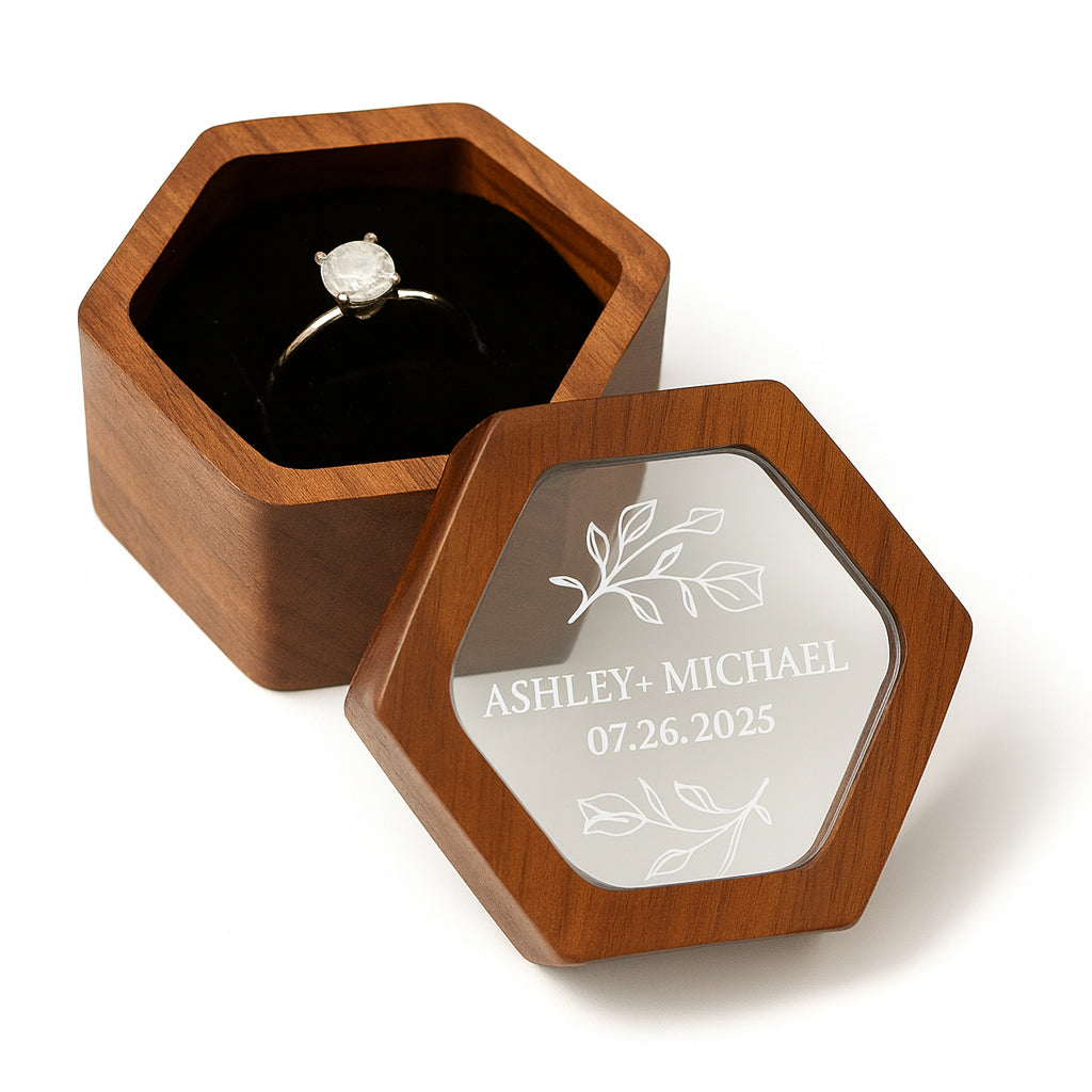 Wooden ring box with engraved names and date on a white background