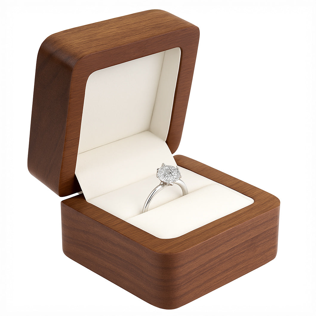 Open walnut wood ring box with ivory interior holding engagement ring