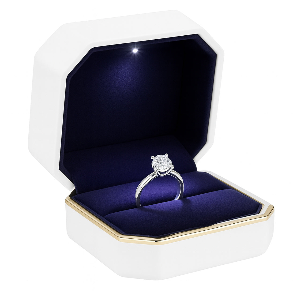 Open white matte ring box with gold trim and LED light holding engagement ring